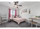 Bright bedroom features a ceiling fan, window, desk, and cozy bed for a warm vibe at 26116 N Thornhill Dr, Peoria, AZ 85383