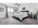 A primary bedroom featuring plush carpeting, a ceiling fan, neutral walls, a large window and artwork at 26116 N Thornhill Dr, Peoria, AZ 85383