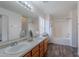Bright bathroom with a double sink vanity, large mirror, wood-look flooring, and a shower-tub combination at 2745 W Sunshine Butte Dr, San Tan Valley, AZ 85144