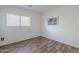 This bedroom features wood-look floors and a bright window overlooking the community at 2745 W Sunshine Butte Dr, San Tan Valley, AZ 85144