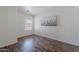 This bedroom features wood-look floors and a bright window overlooking the community at 2745 W Sunshine Butte Dr, San Tan Valley, AZ 85144