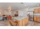 Kitchen features stainless steel appliances and an island with seating, open to the living area at 2745 W Sunshine Butte Dr, San Tan Valley, AZ 85144
