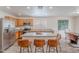 Kitchen boasts stainless steel appliances, wood cabinets, island with seating, and open access to the dining room at 2745 W Sunshine Butte Dr, San Tan Valley, AZ 85144