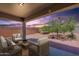 Relaxing covered back patio with stylish outdoor furniture, perfect for enjoying serene evenings and outdoor living at 29870 W Weldon Ave, Buckeye, AZ 85396