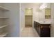 Bathroom featuring double sinks, dark cabinetry, and a walk-in shower with built in shelves at 29870 W Weldon Ave, Buckeye, AZ 85396
