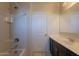 Well-lit bathroom features a shower and bathtub combination with a modern vanity and tiled flooring at 29870 W Weldon Ave, Buckeye, AZ 85396