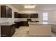 Beautiful kitchen with dark cabinets, granite countertops, and a central island with a sink at 29870 W Weldon Ave, Buckeye, AZ 85396
