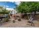 Landscaped backyard with mature trees, seating area, and fire pit, creating a relaxing and inviting outdoor space at 29915 N Maravilla Dr, San Tan Valley, AZ 85143