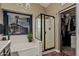 Bathroom featuring a soaking tub, glass enclosed shower, and a view to the backyard, as well as closet access at 29915 N Maravilla Dr, San Tan Valley, AZ 85143