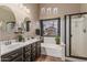 Luxurious bathroom with double sinks, a soaking tub, and a separate shower at 29915 N Maravilla Dr, San Tan Valley, AZ 85143