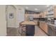 Well-appointed kitchen with stainless appliances, island with seating, and tile flooring for easy maintenance at 29915 N Maravilla Dr, San Tan Valley, AZ 85143