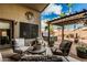 Inviting patio featuring modern furniture set, a spa, pergola, desert landscaping and artistic wall decor at 29915 N Maravilla Dr, San Tan Valley, AZ 85143