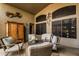 Covered patio showing outdoor furniture, wall art, screens, decorative lizard, and a cabinet at 29915 N Maravilla Dr, San Tan Valley, AZ 85143