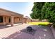 Inviting backyard featuring a brick patio with fire pit and lush green lawn area for relaxation and outdoor activities at 3002 S Marigold Pl, Chandler, AZ 85248