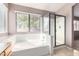 Bathroom featuring a tub, glass shower, and natural lighting from the window at 3002 S Marigold Pl, Chandler, AZ 85248