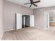 Bedroom featuring a ceiling fan, neutral carpet, and double doors for closet access at 3002 S Marigold Pl, Chandler, AZ 85248
