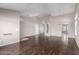 Open living room showcasing dark laminate floors, neutral walls, and an archway leading to other spaces at 3002 S Marigold Pl, Chandler, AZ 85248