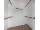 Spacious walk-in closet featuring neutral carpet, white walls, and wooden closet rods for optimal storage solutions at 3002 S Marigold Pl, Chandler, AZ 85248