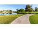 Scenic walking path near a tranquil pond, surrounded by lush grass and mature trees at 3002 S Marigold Pl, Chandler, AZ 85248