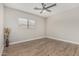 This bedroom features neutral walls, wood floors, a ceiling fan, and a window at 3212 W Lucia Dr, Phoenix, AZ 85083