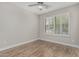 Bedroom with wood-look floors, neutral paint, ceiling fan, and a window with shutter blinds at 3212 W Lucia Dr, Phoenix, AZ 85083