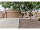 Tan home featuring a two car garage, desert landscaping, and a sidewalk leading to the front door at 3212 W Lucia Dr, Phoenix, AZ 85083