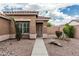 A quaint tan home featuring desert landscaping, with a sidewalk leading to the front door at 3212 W Lucia Dr, Phoenix, AZ 85083