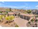 Aerial view of a desert community home with a tile roof, lush landscaping, and multi-car garage at 3217 N Piedra Cir, Mesa, AZ 85207