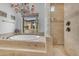 Serene bathroom featuring a soaking tub and shower with views of the desert landscape at 3217 N Piedra Cir, Mesa, AZ 85207