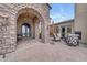 Elegant courtyard featuring a stone archway, chandelier, and outdoor seating area with fireplace at 3217 N Piedra Cir, Mesa, AZ 85207
