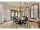 Cozy dining room with a round table, chandelier, and large windows for natural light at 3217 N Piedra Cir, Mesa, AZ 85207