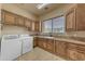 Laundry room with wooden cabinetry, sink, and newer washer and dryer at 3217 N Piedra Cir, Mesa, AZ 85207