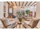 This living room features beamed ceilings, a stone fireplace, and large windows for natural light at 3217 N Piedra Cir, Mesa, AZ 85207
