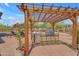 Inviting outdoor kitchen with pergola, stainless steel grill, mini-fridge, and brick pavers for entertaining at 3217 N Piedra Cir, Mesa, AZ 85207