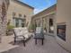 Charming outdoor patio with comfortable seating, a fireplace, and access to the home's interior at 3217 N Piedra Cir, Mesa, AZ 85207