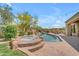 Backyard pool and spa with rock waterfall, seating, and lush landscaping at 3217 N Piedra Cir, Mesa, AZ 85207