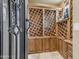 Charming wine cellar featuring custom wooden lattice racks and ample bottle storage behind iron door at 3217 N Piedra Cir, Mesa, AZ 85207