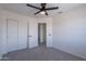 Neutral bedroom with ceiling fan, closet with sliding door, and an open door to another room at 3233 E Sequoia Dr, Phoenix, AZ 85050