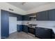 Modern kitchen with stainless steel appliances, blue cabinets, white countertops, and a stylish tile backsplash at 3233 E Sequoia Dr, Phoenix, AZ 85050