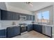Modern kitchen with stainless steel appliances, blue cabinets, white countertops, and a stylish tile backsplash at 3233 E Sequoia Dr, Phoenix, AZ 85050
