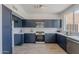 Modern kitchen with stainless steel appliances, blue cabinets, white countertops, and a stylish tile backsplash at 3233 E Sequoia Dr, Phoenix, AZ 85050