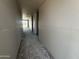 A hallway in a new home build with gray flooring and drywall walls going to the other side of the house at 32615 N Newby Dr, San Tan Valley, AZ 85143