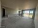 A large unfinished living room in a new home build with gray floors, large sliding doors and a window at 32615 N Newby Dr, San Tan Valley, AZ 85143