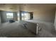 A large unfinished living room in a new home build with gray floors, large sliding doors and windows at 32615 N Newby Dr, San Tan Valley, AZ 85143