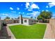 Backyard view featuring artificial grass, gravel, and a house with a chimney at 338 W Taro Ln, Phoenix, AZ 85027