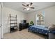 This bedroom has a ceiling fan, tile floor, and a window looking out to the neighborhood at 338 W Taro Ln, Phoenix, AZ 85027