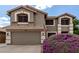 Charming home showcasing a two-car garage and a vibrant, purple blooming shrub in the front yard at 3730 S Chaparral Rd, Apache Junction, AZ 85119