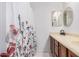 Bathroom vanity featuring a decorative floral shower curtain, oval mirror, and classic faucet at 3756 E Clovis Ave, Mesa, AZ 85206