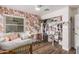 Bedroom features floral wallpaper, wood floors, and organized closet with clothing and storage bins at 3756 E Clovis Ave, Mesa, AZ 85206