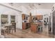 Open kitchen with wood cabinets, granite counters, island seating, and views of the dining area at 3756 E Clovis Ave, Mesa, AZ 85206